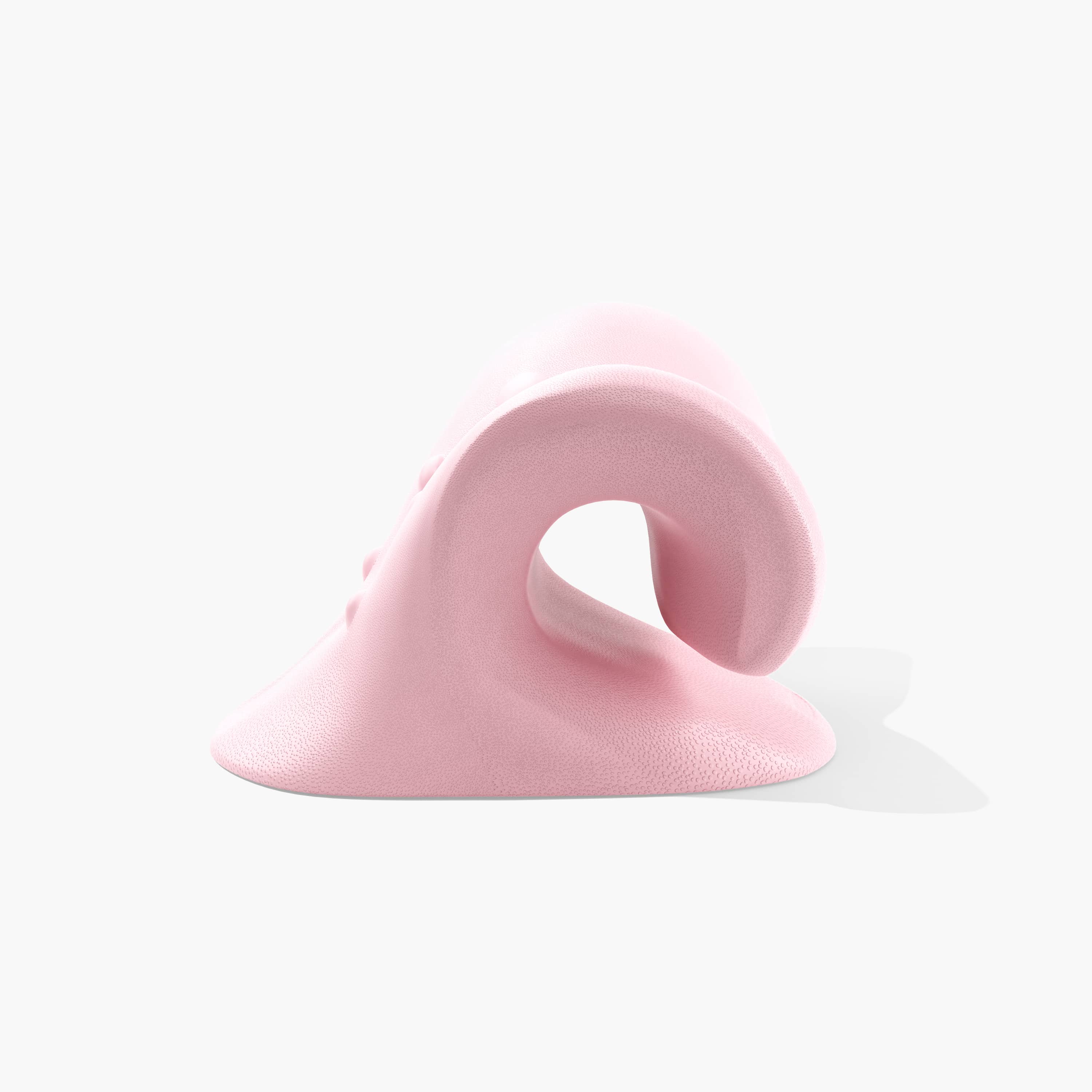 Juno by Nomisk. A pink cervical traction pillow that instantly relieves neck pain. Relieve tension, improve sleep, posture and blood flow by using Juno to stretch out your neck. Shown here from a profile view.